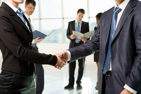 deux collaborateurs en costume qui se serrent la main