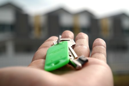 Main qui tend une clé de maison